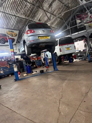 Cars raised on ramps inside the Kam Autos workshop in Derby