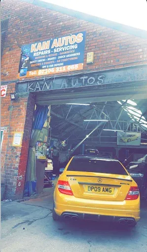 Yellow car parked outside the Kam Autos garage entrance in Derby